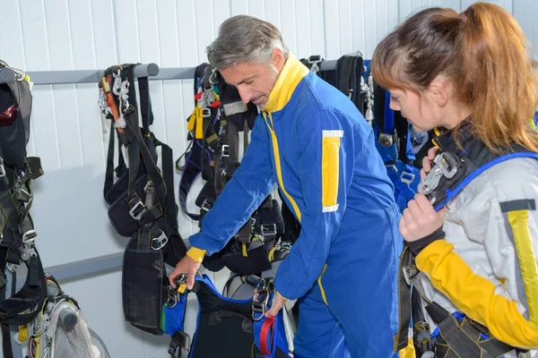 Mężczyzna instruktor z kobiet student przygotowuje przed skoki spadochronowe — Zdjęcie stockowe