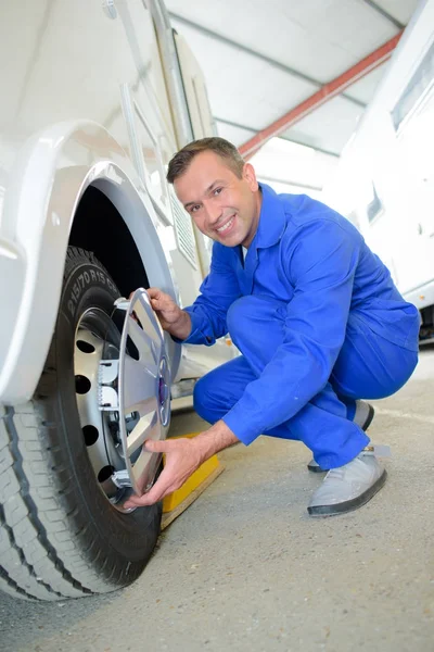 Mechanic fitting hubcap to wheel — Stock Photo, Image