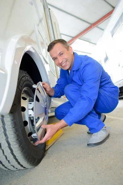 Mechaniker montieren Radkappe an Rad — Stockfoto