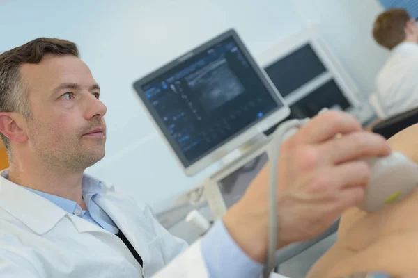 Técnico de ultrasonido mirando al paciente — Foto de Stock