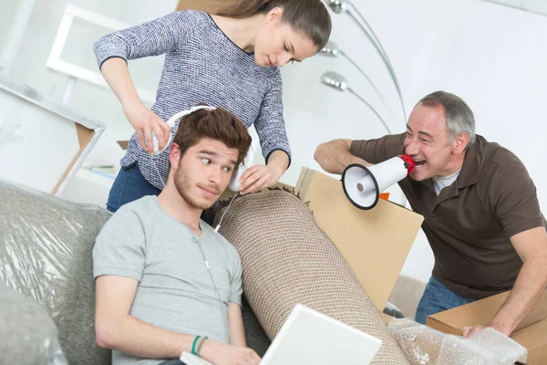 Familie verpakking om dozen en luie zoon bewegen doet niets — Stockfoto