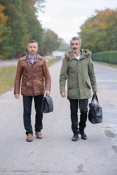 Два бизнесмена, идущие вместе за пределами офиса в городе — стоковое фото