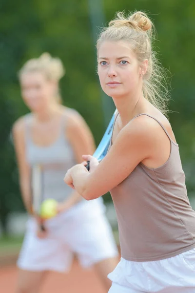 Women playing tennis doubles