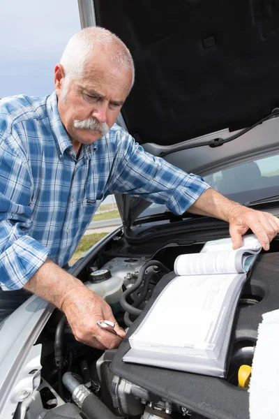 Hombre mayor comprobar los niveles y el mantenimiento de su coche — Foto de Stock