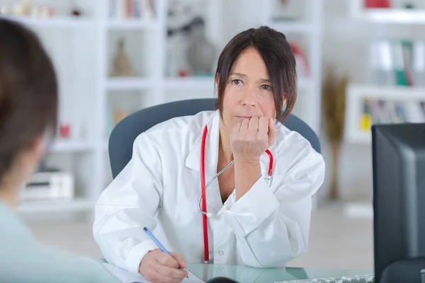 Medico donna ascoltando il suo pazientenell'ufficio — Foto Stock