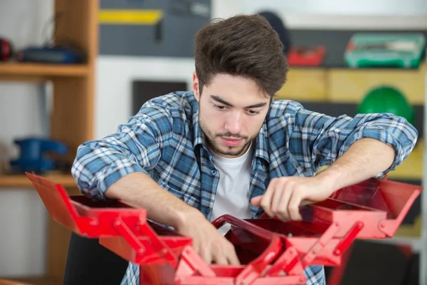 Portret van man zijn gereedschapskist thuis uitpakken — Stockfoto