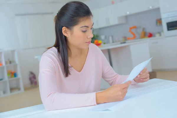 Frau liest Brief zu Hause im Wohnzimmer — Stockfoto