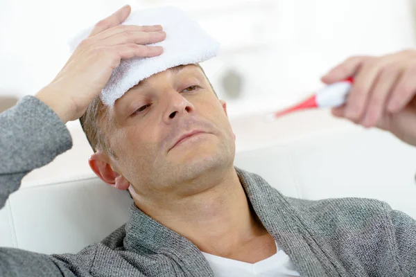 Man checking his fever — Stock Photo, Image