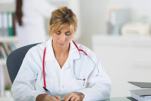 Médico feminino escrita e clínica — Fotografia de Stock