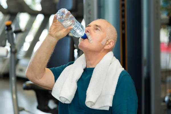 Senior man drinking water after exercising — Stock Photo, Image