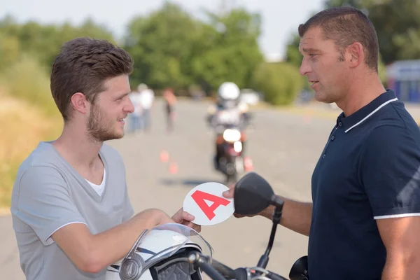 Giving sticker to a motorbike student — Stock Photo, Image