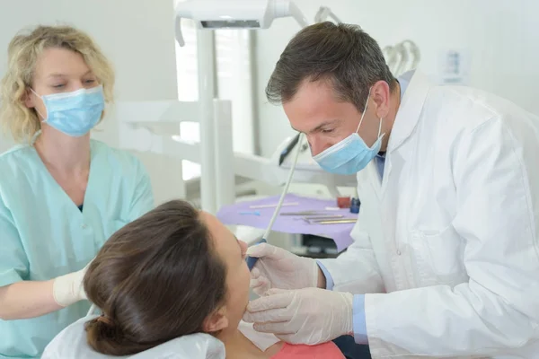 Dentist assistant and patient at stomatology office — Stock Photo, Image