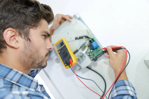 Comerciante fixação problema elétrico com secador de mão — Fotografia de Stock