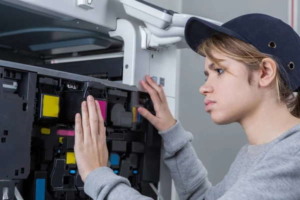 Жіночий технік, що фіксує принтер — стокове фото