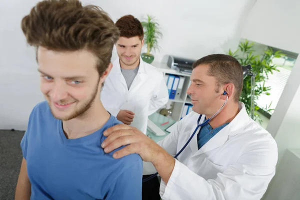 微笑着学生的物理治疗师和年轻的病人 — 图库照片