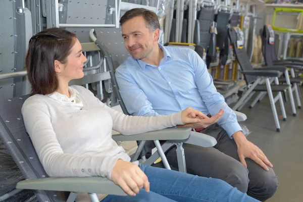 Paar probiert einen Stuhl aus — Stockfoto