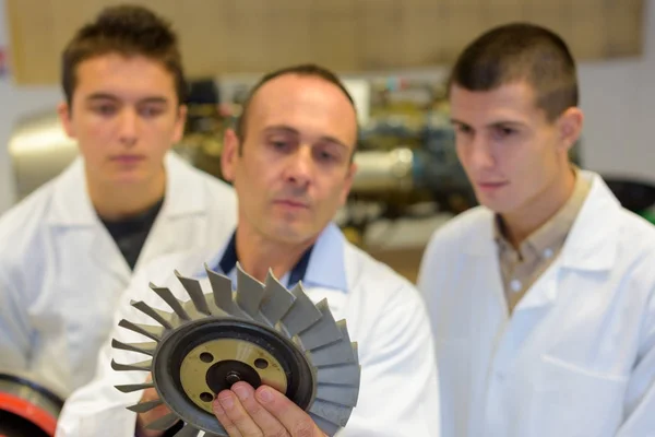 Trois hommes avec une pièce de machine circulaire — Photo