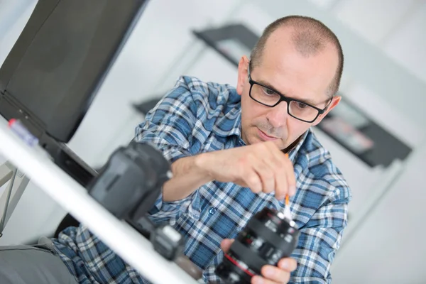 Technicien examinant et réparant la caméra dslr — Photo