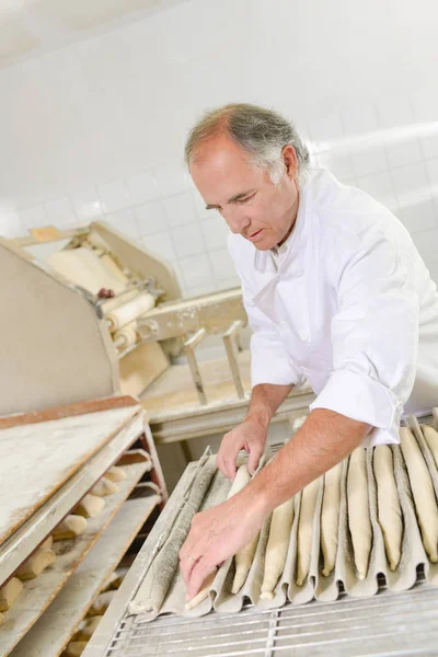 Homem preparando baguete e baguete — Fotografia de Stock