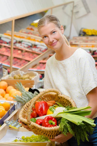 Lady holding basket of vegetables — Stock Photo, Image