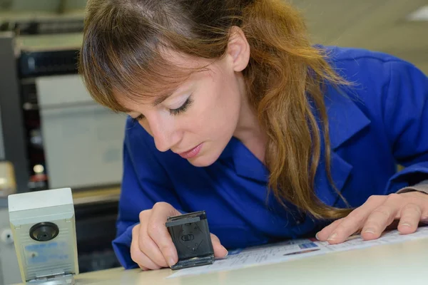 Mujer en uniforme azul usando un sello —  Fotos de Stock