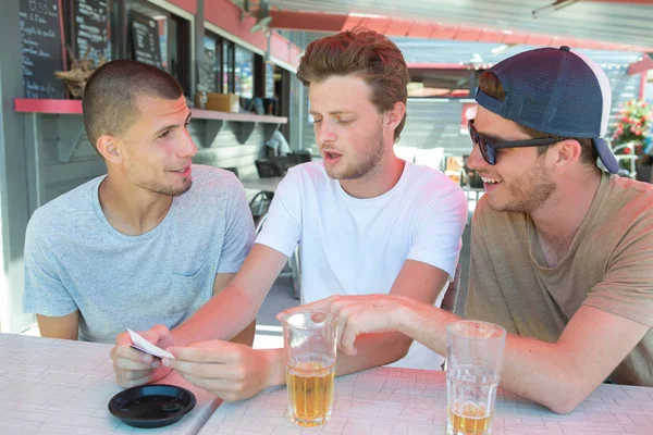 Três homens bebendo cerveja no bar do terraço — Fotografia de Stock