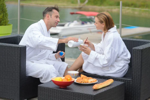 Couple eating breakfast on a table at beautiful lake — Stock Photo, Image