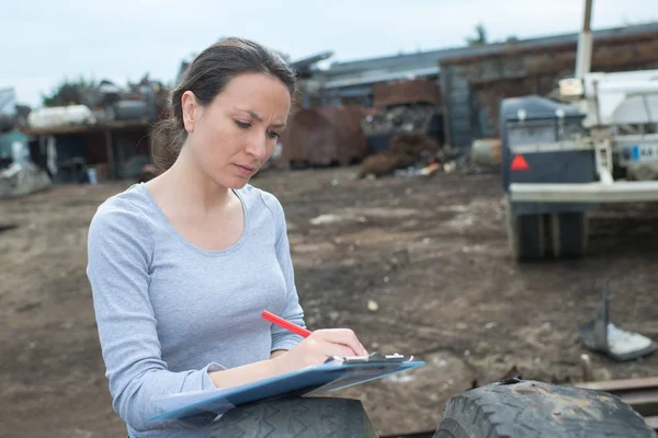 Técnico feminino rural escrevendo leitura de medidor na área de transferência ao ar livre — Fotografia de Stock