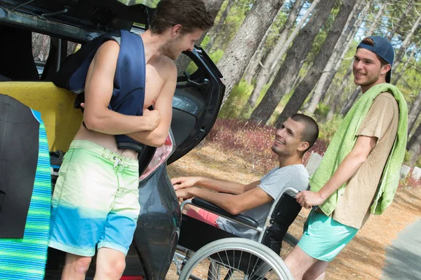 Niepełnosprawny nastolatek i jego przyjaciele, korzystających z plaży latem — Zdjęcie stockowe
