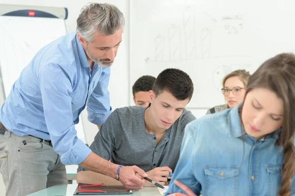 Enseignant expliquant aux élèves en classe — Photo