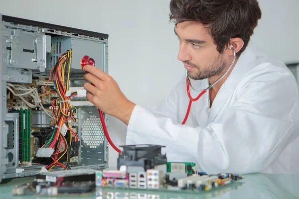 Mann hält Stethoskop an Computer — Stockfoto