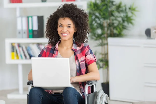 Signora in sedia a rotelle utilizzando il computer portatile — Foto Stock