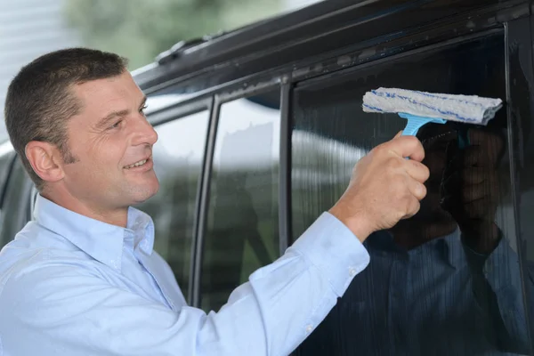 Homem limpando a janela do carro — Fotografia de Stock