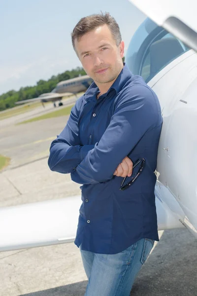 Porträt eines Mannes, der sich an Flugzeuge lehnt — Stockfoto