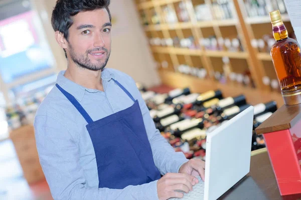 Joven enólogo que trabaja con un ordenador portátil — Foto de Stock