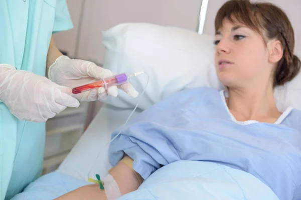 Enfermeira tira uma amostra de sangue de paciente bonito — Fotografia de Stock