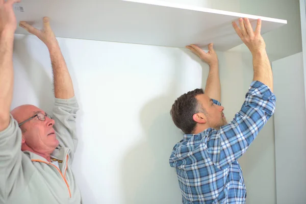 Travailleurs installant des panneaux de plafond de bâtiment dans la construction de maisons — Photo