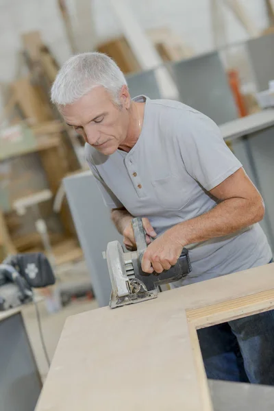 Senior timmerman met een cirkelzaag — Stockfoto