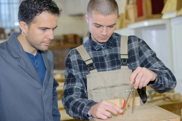 Jonge man in houtwerk opleiding met professionele docent — Stockfoto