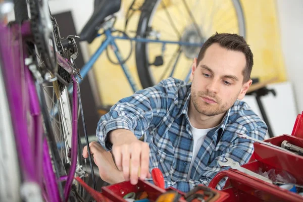 Geschäftsinhaber repariert Fahrrad — Stockfoto