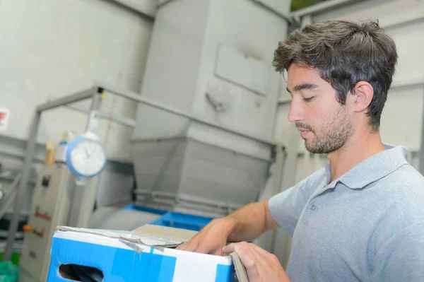 Worker preparing contents of carton — Stock Photo, Image