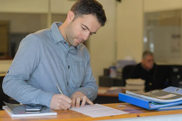 Mann unterschreibt Dokumente beim Notar — Stockfoto