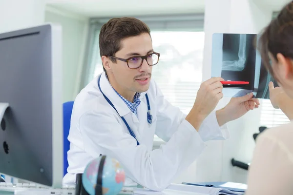 Arzt zeigt Patient Röntgenergebnisse — Stockfoto