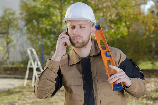 Bauarbeiter mit Handy vor Ort — Stockfoto