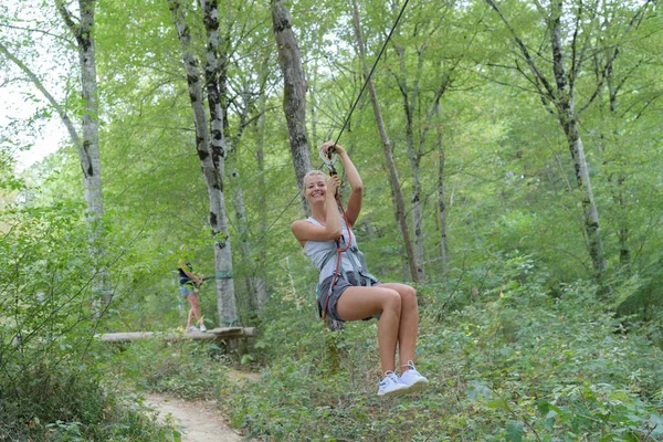 Frau klettert auf Hochseil im Erlebnispark — Stockfoto