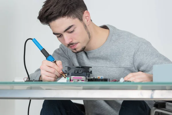 Junger, gutaussehender Computerreparateur konzentriert sich auf seine Arbeit — Stockfoto