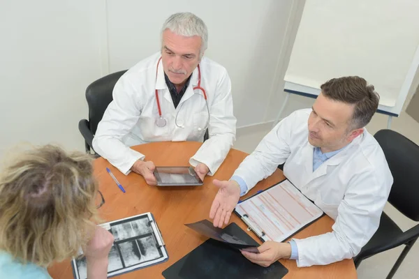 Team van artsen met bijeenkomst bij kliniek — Stockfoto