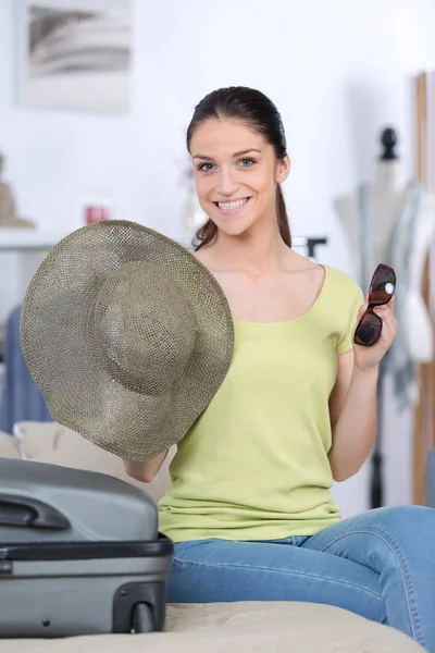 Smiling female packing luggage — Stock Photo, Image