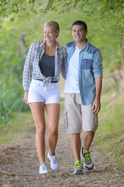 Casal andando ao longo do caminho do país — Fotografia de Stock