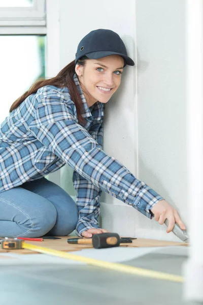 Young tradeswoman laying down linoleum flooring — Stock Photo, Image